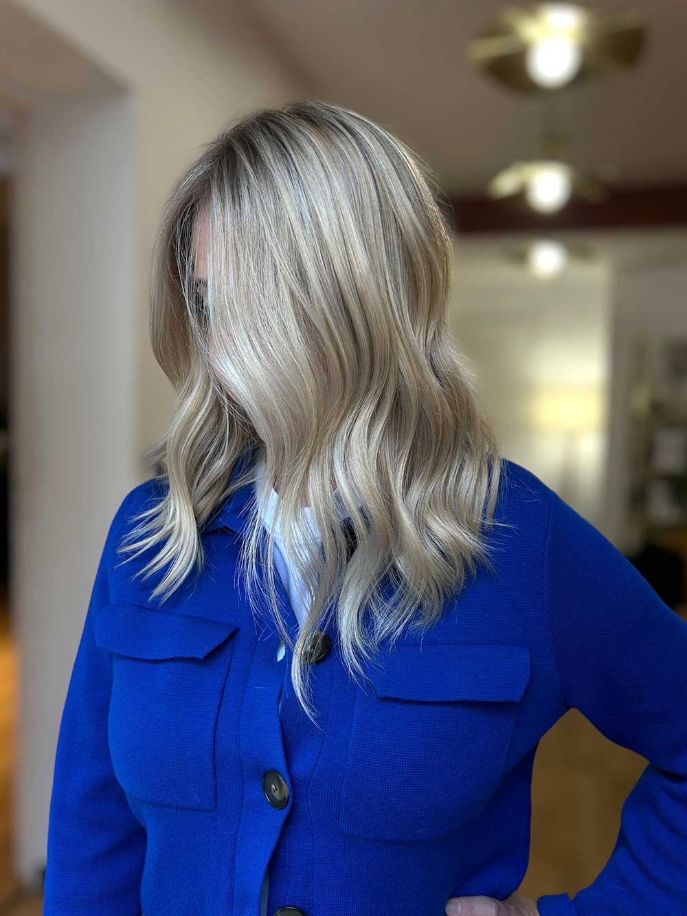 Une femme qui montre ses cheveux avec une coloration type balayage réalisée par le coiffeur à Bordeaux Dissemblance