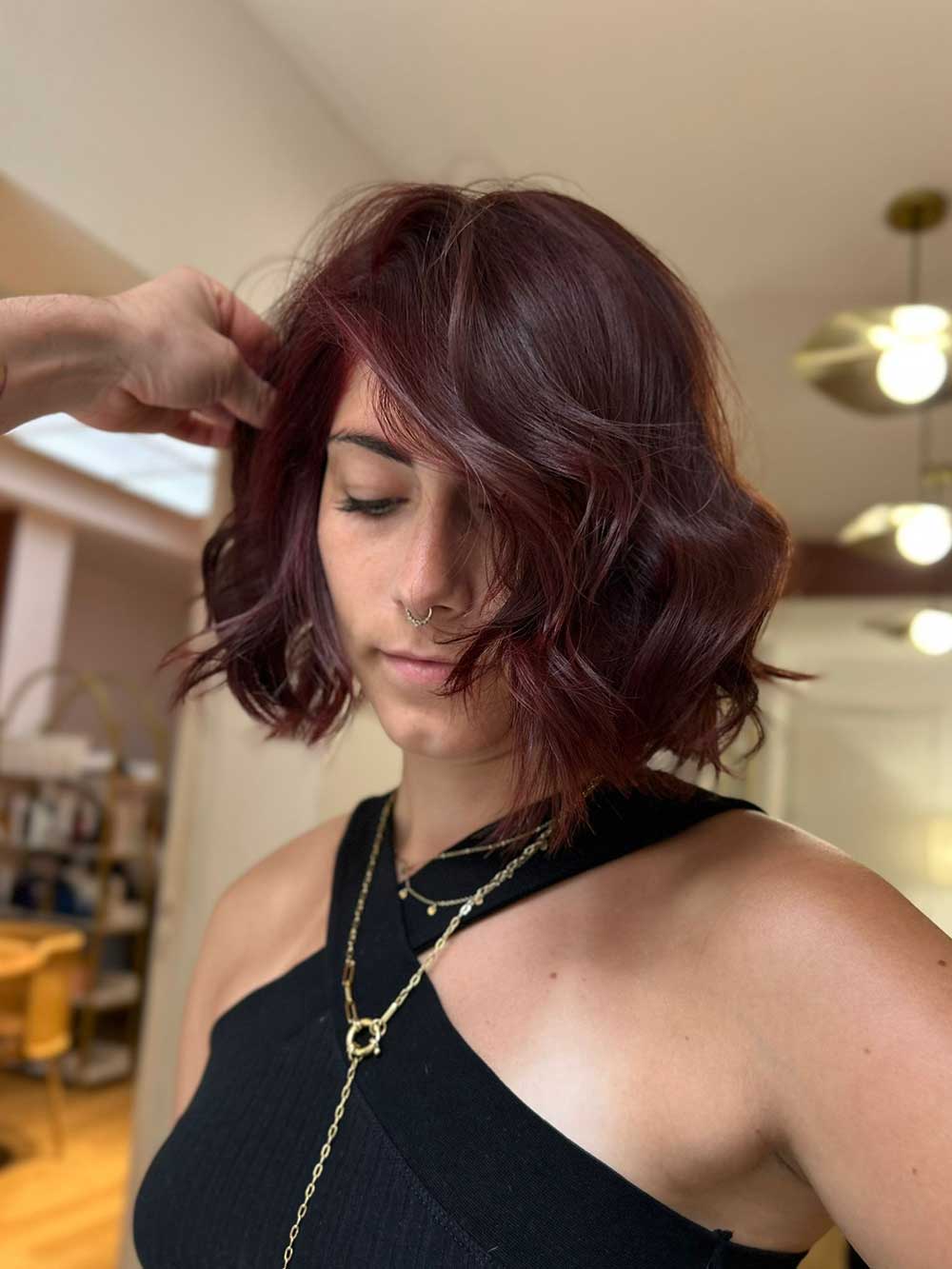 Une femme qui montre sa coupe de cheveux avec une coloration réalisée par le coiffeur à Bordeaux Dissemblance
