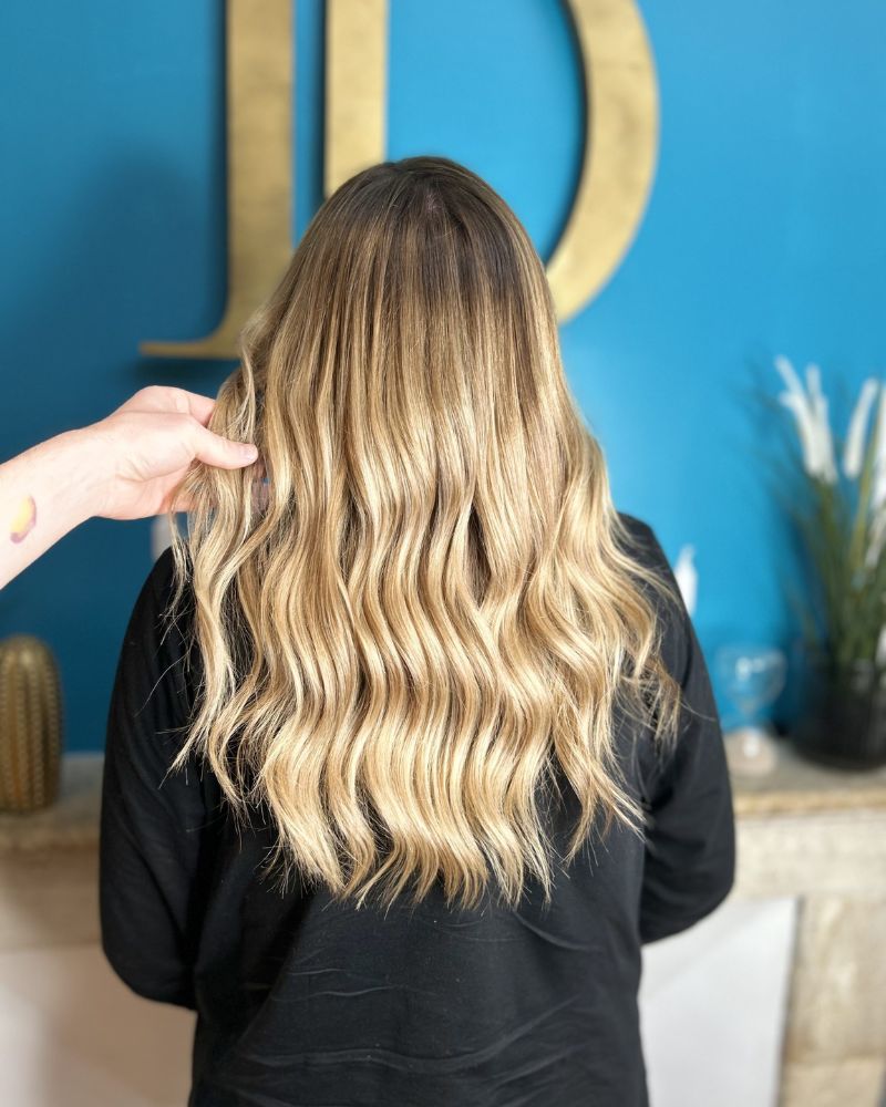 Des longs cheveux blonds colorés par le coiffeur à Bordeaux Dissemblance.